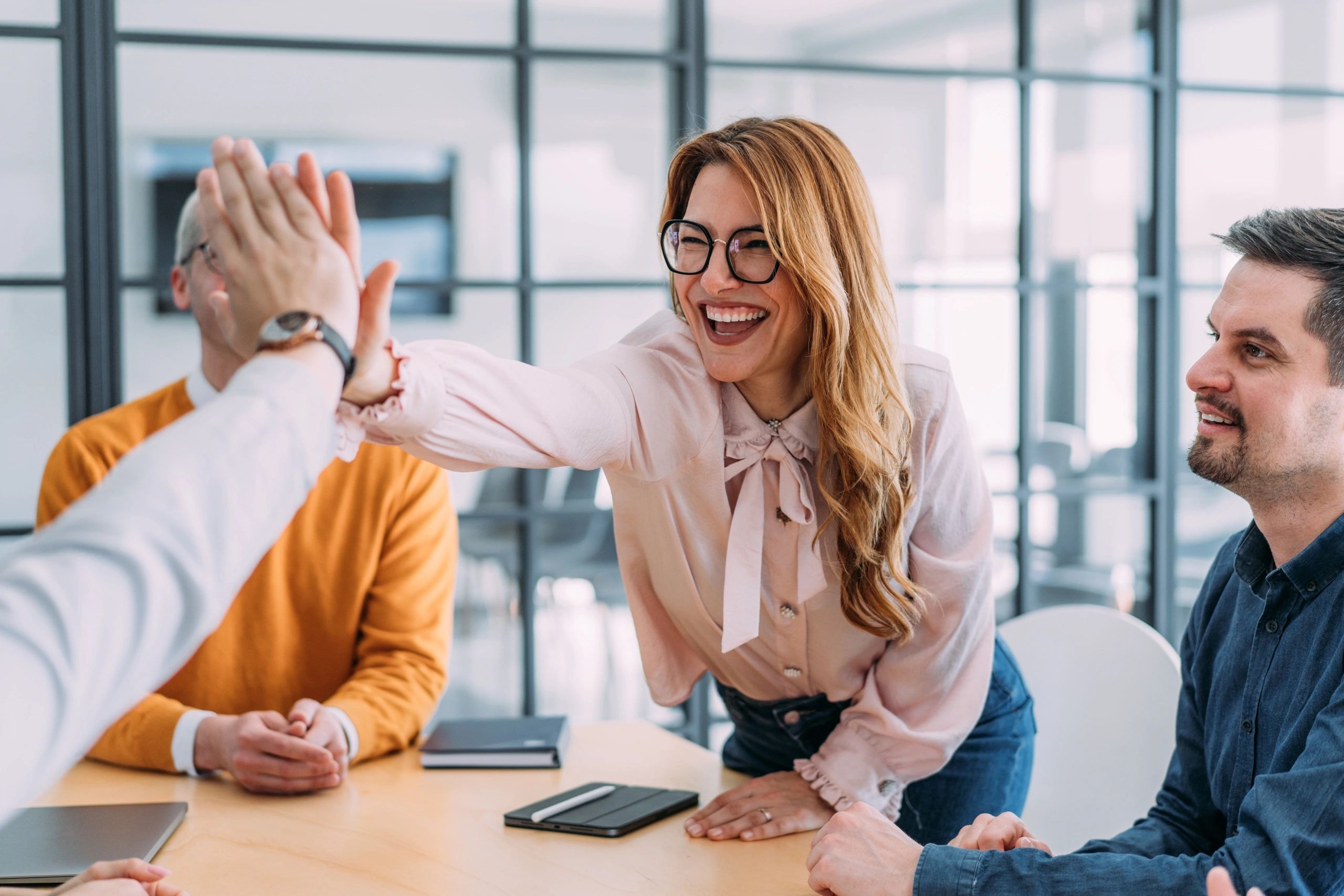 Équipe diverse célébrant un succès dans un bureau moderne